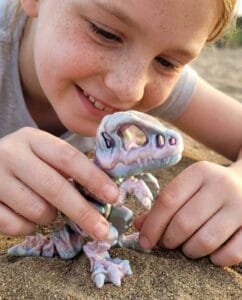Child playing with articulated t-rex toy showing why kids love articulated toys